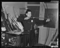 Police officer poses with weapons submitted to the Los Angeles Police Department, Los Angeles, 1942