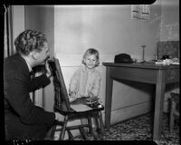 Abandoned child smiles at the camera as an unidentified man looks on, Los Angeles, October 30, 1937