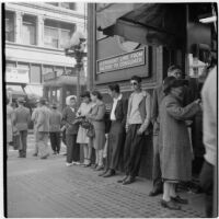 Woman talking to truant teenagers standing against a building, Los Angeles, March 1946