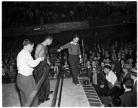 Heavyweight wrestler Gino Garibaldi looks down at opponent Sandor Szabo from the ring in Olympic Auditorium, Los Angeles, October 13, 1937