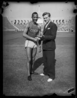 Jesse Owens shakes hand with unidentified spokesperson for USC, Los Angeles, 1935