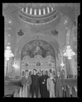 Clergy, civic leaders and artist standing in nave with dome and Iconostasis behind them during opening of St. Sophia Greek Orthodox Cathedral in Los Angeles, 1952