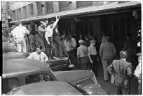 Crowd of workers standing on cars and gathering for a strike, Los Angeles, 1937