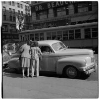 Two women talking to someone in a parked car, Los Angeles, March 1946