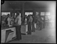 Unidentified men weigh goods at a cooperative, Los Angeles, 1930s