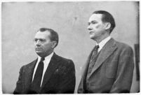 Murder suspect Robert S. James standing between two unidentified men in court, Los Angeles, 1936