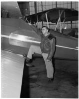 Paul Mantz, motion picture stunt pilot and consultant, poses with airplane. Circa February 1936