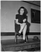 Emma Boyts, 15, sitting on a chair on top of a desk, Los Angeles, November 13, 1939