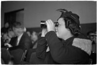 Female spectator uses binoculars to view court proceedings during the trial of Police Captain Earle E. Kynette, Los Angeles, 1938