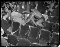 Wrestlers Vincent López and Gino Garibaldi take their fight into the stands at Olympic Auditorium, Los Angeles, 1937