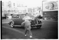 Restaurant workers waiting to serve customers outside a drive-in restaurant, Los Angeles