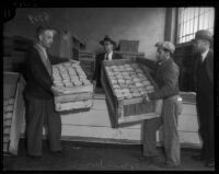 Unidentified men move goods in wooden crates, Los Angeles, 1930s
