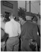 Policeman and other men gathered outside of the Department of Motor Vehicles