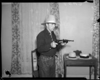 Dr. Ralph Wagner poses with guns and hat, Los Angeles, 1930s