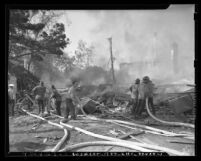 Firemen hosing down rubble and flames at Hillcrest Country Club explosion in Los Angeles, Calif., 1948