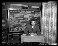 Richard M. Nixon seated before Los Angeles Press Club election scoreboard showing him winning a U.S. Senate seat, 1950