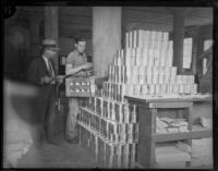 Two unidentified men move canned goods, Los Angeles, 1930s