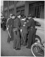 Police arresting Frank Bincia in front of Pacific Press, Inc. due to an altercation with John Sullivan, Los Angeles, August 6, 1946