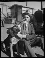 Bearded man sits with a dog at the Unemployed Citizens' League of Santa Monica, 1930s