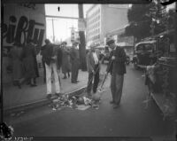 Unknown men sweeping corner of Hollywood Blvd. and Ivar St., Los Angeles, circa November 1935