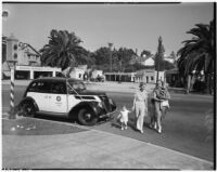 Two women with children cross the street in front of LAPD officers Jack Hoyt and Douglas Gourley, Los Angeles