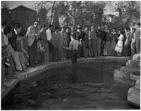 Man stands in a fountain on USC's campus while a crowd watches, Los Angeles, 1946