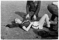 Sports officials examining a USC track athlete for injury, Los Angeles, 1937