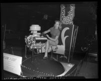 Shirley Buchanan and De Soto fire dome v-eight motor at the 1952 Los Angeles International Automobile Show, Calif