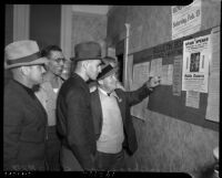 Maritime workers gathered around a telegram announcing the end of the 98-day coast maritime strike, Los Angeles, 1937