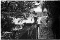 View through the trees towards a swimming pool on the estate of film comedian Harold Lloyd and his wife Mildred, Beverly Hills, 1927