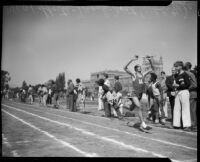 Track athlete finishes relay race during the All-City High School track and field meet, Los Angeles, 1937