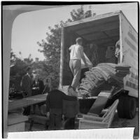 Louis M. Rich family watches as their possessions are loaded into a moving van, Los Angeles, November 22, 1945