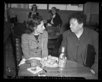 Artist Diego Rivera seated at restaurant table with actress Paulette Goddard, circa 1940