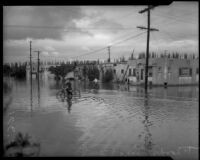 Children play and ride bicycles in flood waters, Long Beach, circa 1930s