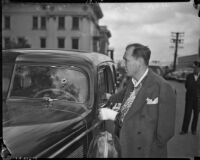 Buron Fitts examining his car after recovering from an assassination attempt, Los Angeles, 1937