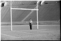 Photographer on the Coliseum field during a game between the Loyola Lions and the Galloping Gaels of St. Mary's, Los Angeles, 1937