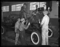 Men at work completing an automobile at the Los Angeles Studebaker assembly plant in Vernon, CA. Circa January 2, 1936