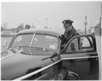 Police officer Dick Barlow writing a ticket for Dick Russell during a planned race to demonstrate the importance of following traffic laws, Los Angeles, 1947