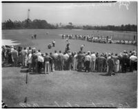 Spectators watch a golfer on the putting green during a tournament at the L.A. Country Club, Los Angeles