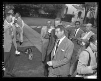 Joe DiMaggio, surrounded by reporters, leaving his home in Los Angeles, Calif., 1954