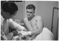 Boxer Bob Nestell getting his hand taped up before a fight, Los Angeles, 1937