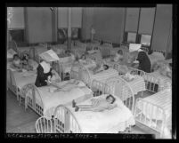 Nuns attending to little girls in dormitory of Daughters of Charity orphanage at 917 S. Boyle Ave. in Los Angeles, Calif., 1950