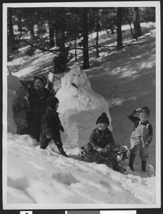 Five children surrounding a snowman in the mountains, ca.1930