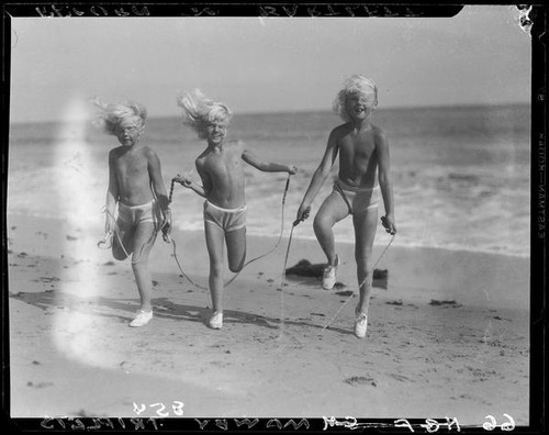 Mawby triplets jumping rope on beach, Malibu, 1928