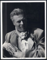 Aldous Huxley portrait, leaning on elbow, hands clasped, scarf around neck [descriptive]