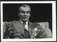 Aldous Huxley, seated in chair and gesturing hands, black background (1), identical image [descriptive]