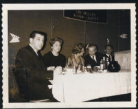 Aldous and Laura Huxley seated at table with unidenitified people [descriptive]