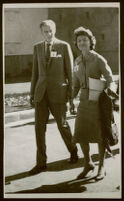 Aldous and Laura Huxley, walking outside in sunlight, dressed in suits [descriptive]