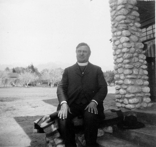 Father Benedict Florian Hahn of the St. Boniface Indian/Industrial School sitting on porch of the C. O. Barker residence