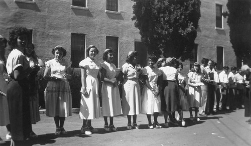 Students waiting in line next to school building on St. Boniface Indian/Industrial School grounds